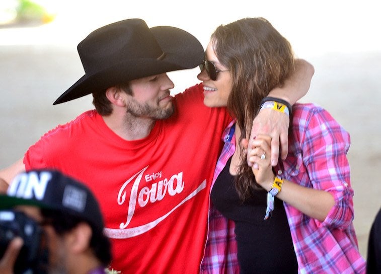 Actors Ashton Kutcher in a cowboy hat and Mila Kunis attend day 1 of 2014 Stagecoach