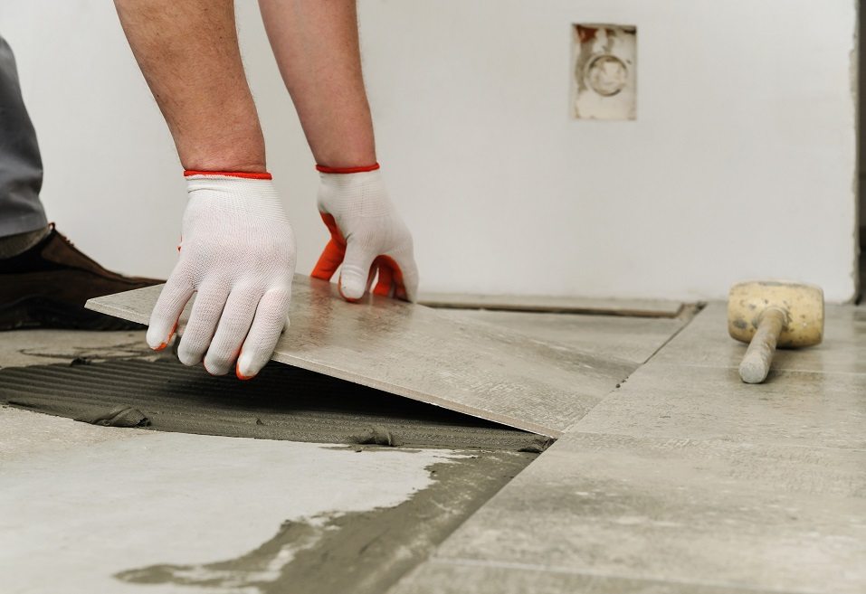 Worker placing ceramic floor tile
