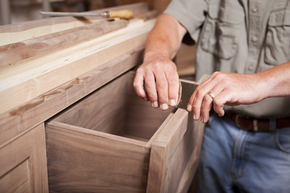 cabinet maker smoothing out a drawer for a kitchen remodel