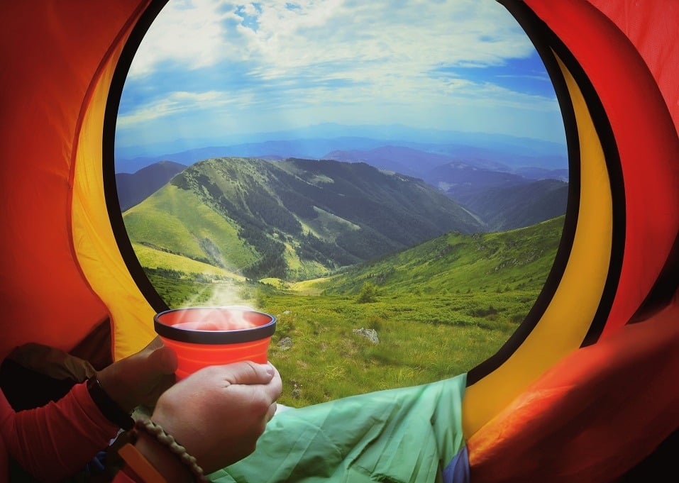 Woman lying in a tent with coffee