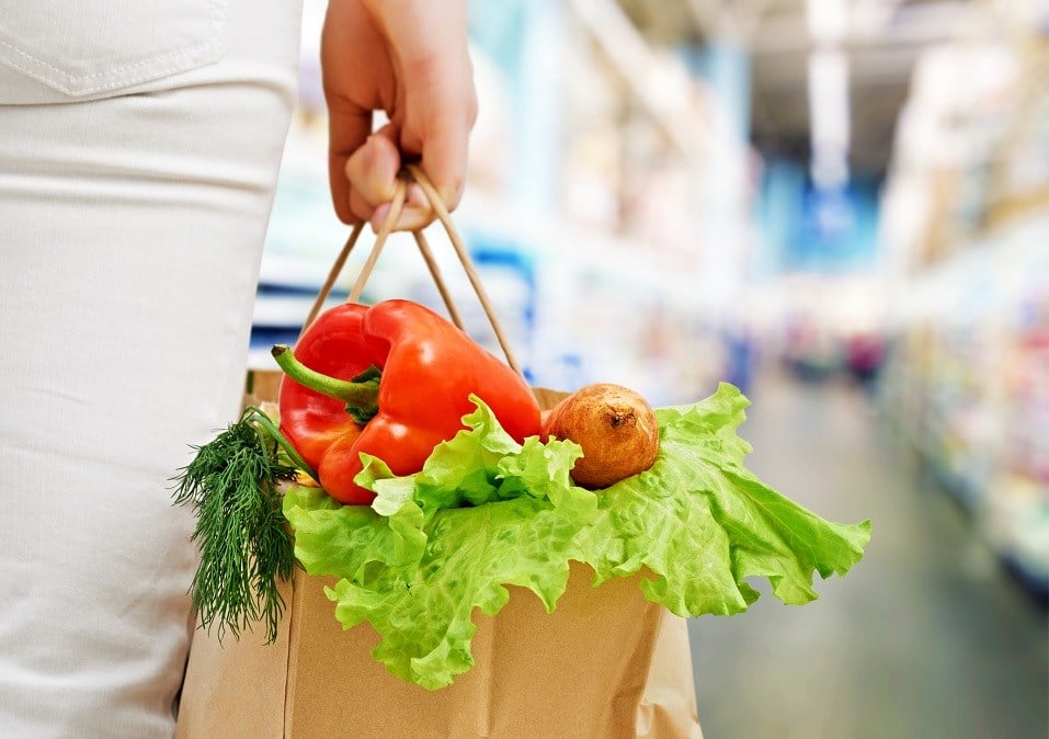 woman holding a bag of fruit