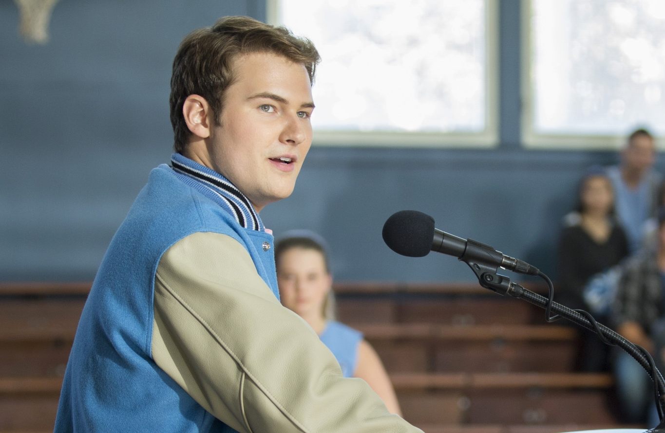 Bryce stands at a microphone in a scene from 13 Reasons Why 