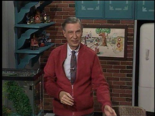 Fred Rogers next to a fish tank on set
