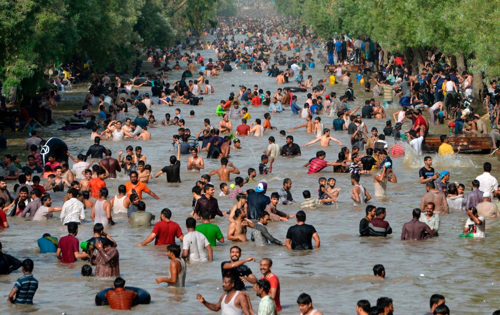 People cool themselves off in a water channel during a heat wave in Pakistan