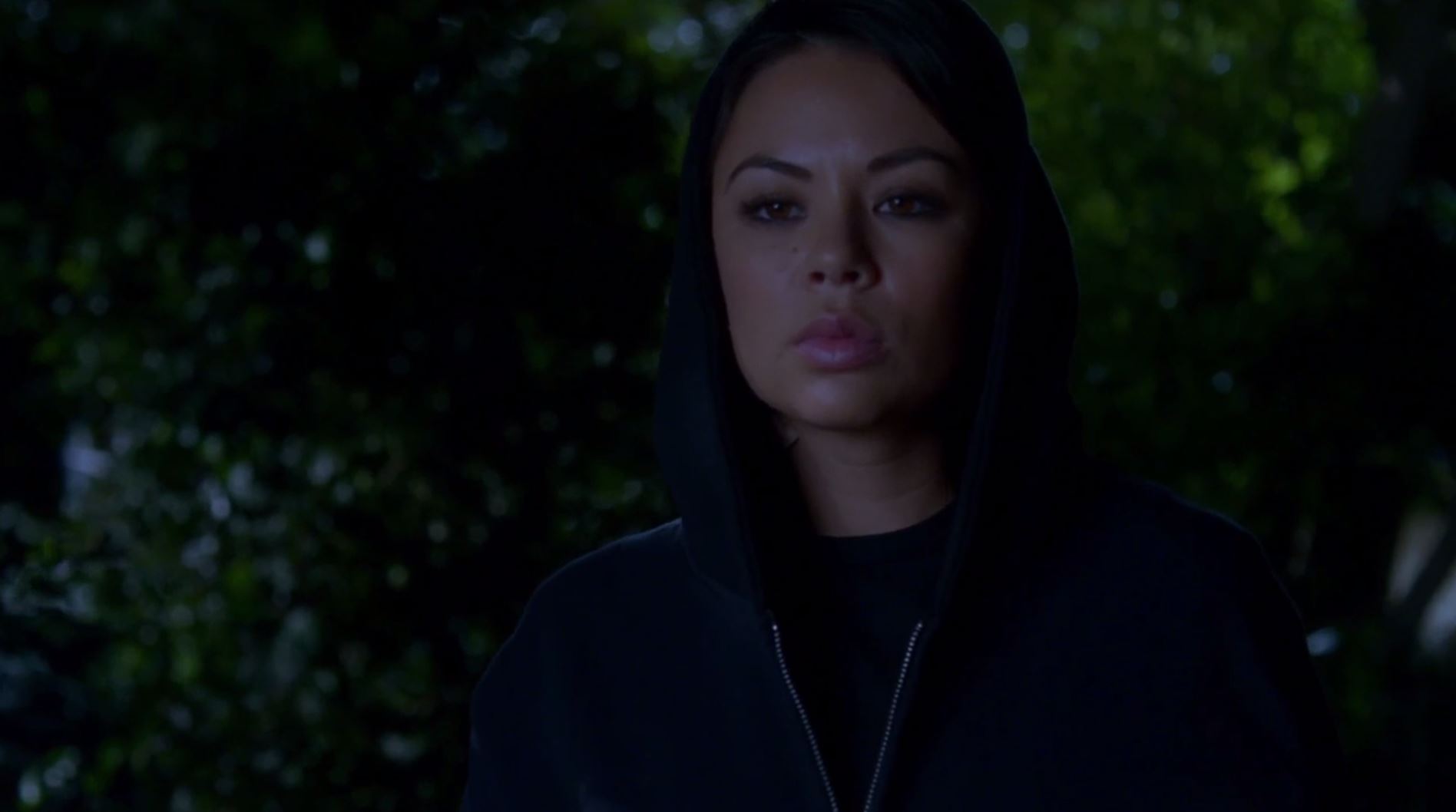 Mona in a black hoodie at night