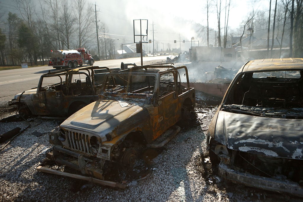 The remains of a Jeep rental business smolders after a wildfire in Gatlinburg, Tennessee