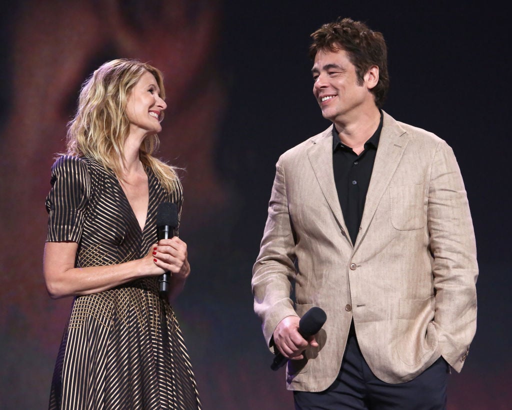 Laura Dern and Benicio del Toro smile at each other on stage