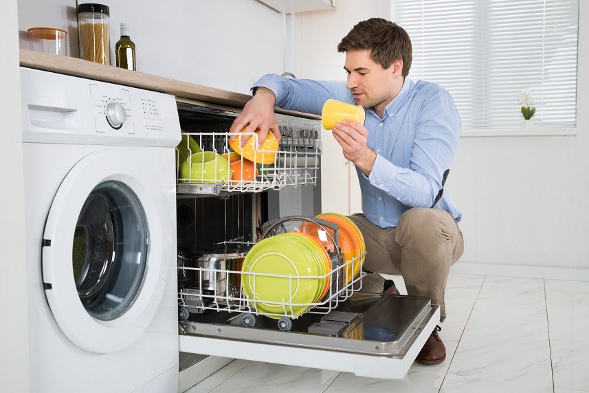 Man Arranging Dishes In Dishwasher