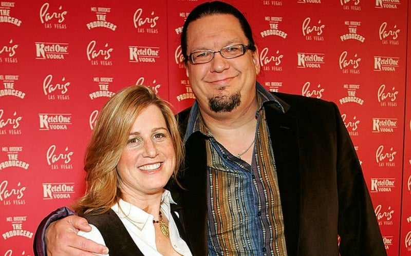 Penn Jillette has his arm around Emily on the red carpet.