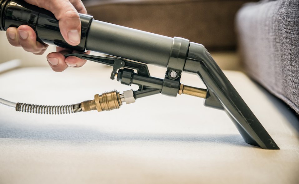 Cleaning couch with professional spray cleaner