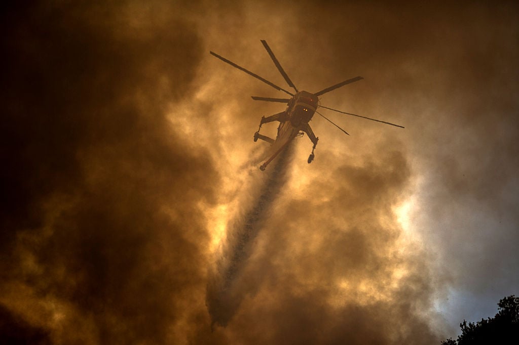a helicopter making a drop during a wildfire