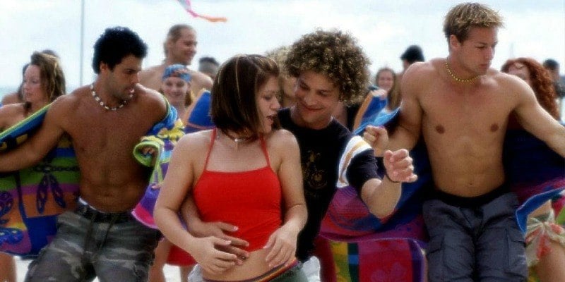 Kelly Clarkson and Justin Guarini are dancing together on a beach.