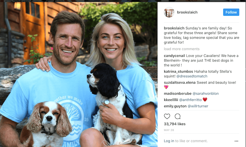 Brooks Laich and Julianne Hough pose in blue T-shirts holding their dogs