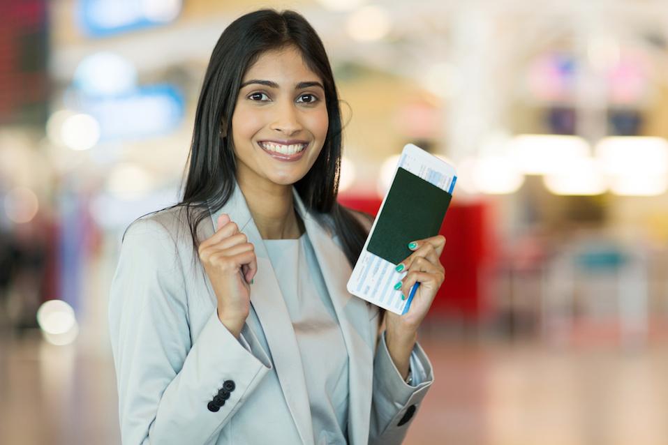 indian woman holding passport and boarding pass