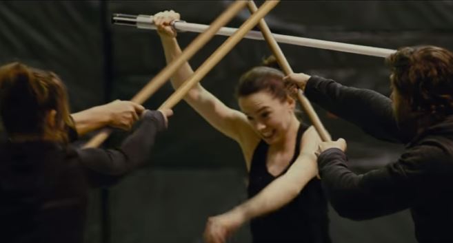 Daisy Ridley trains against three other fighters with a faux lightsaber