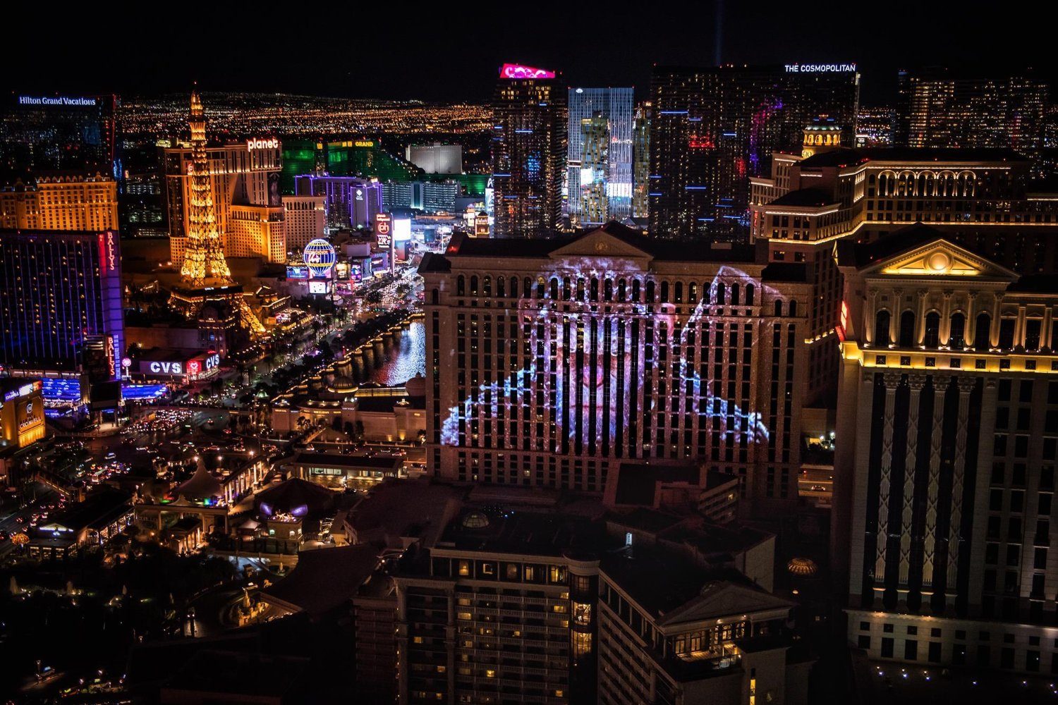 A city at night and an image of an ape projected onto a building