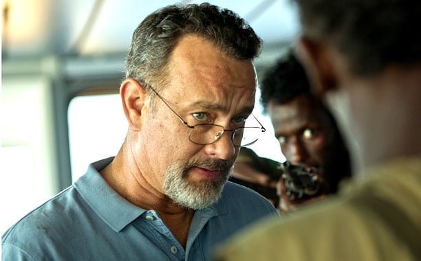 Tom Hanks looks through his glasses at the men invading his ship in Captain Phillips