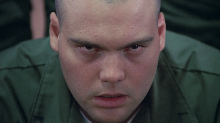 Vincent D'Onofrio in a green shirt, glaring up at the camera