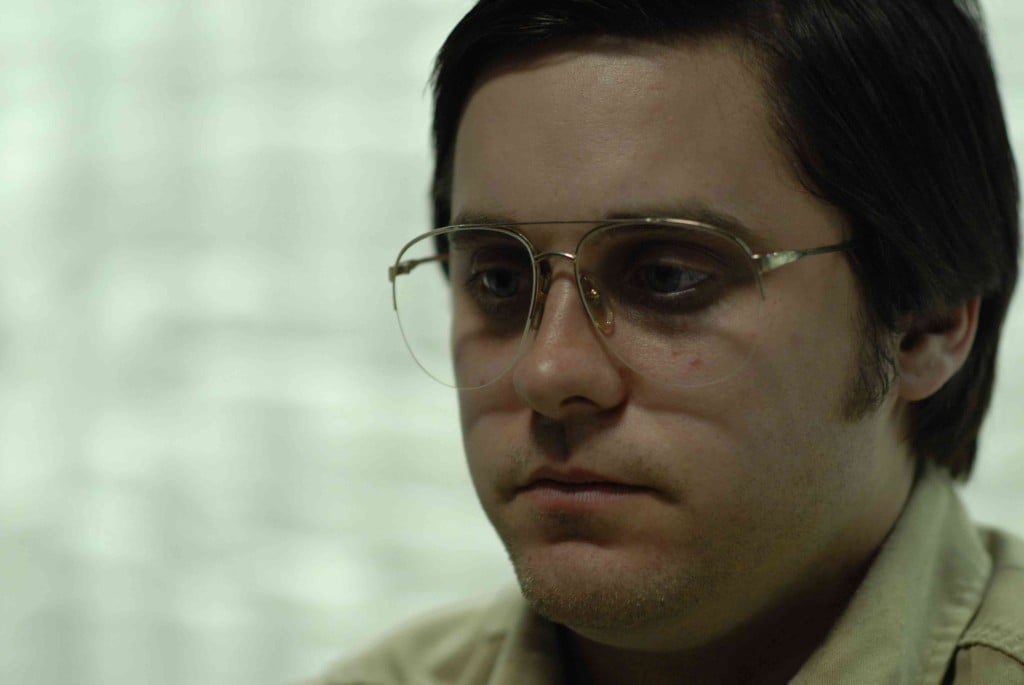 Jared Leto in a fat suit, wearing large glasses and looking to the left of the frame