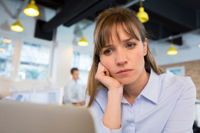 A burnt out employee staring at a computer screen