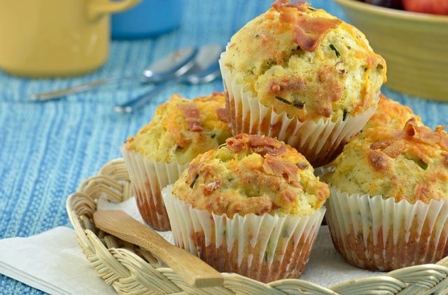 Fresh baked bacon cheddar muffins wicker tray on blue background