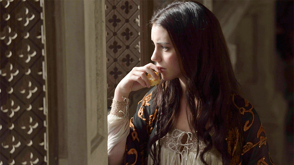 A woman looks out a palace window in Reign