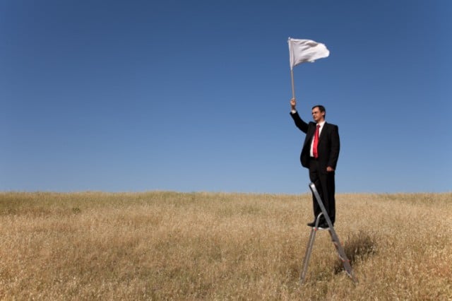 A man holding a white flag of surrender 
