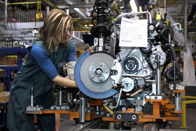 A worker builds an engine in a Ford factory