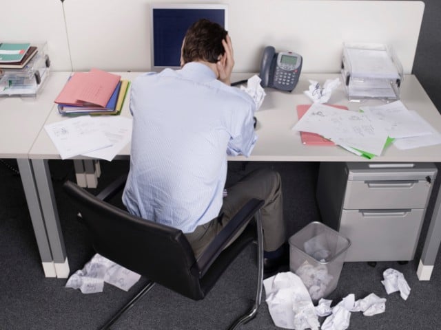 Man with crumpled papers at desk