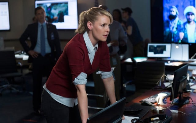 Katherine Heigl is leaning on a desk looking worried.