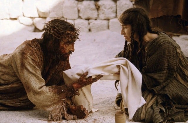 Jim Caviezel's Jesus Christ holds a baby in his bloodied hands in a scene from Passion of the Christ