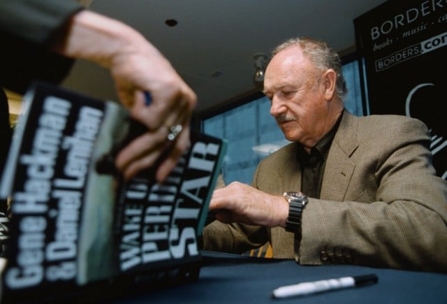 Gene Hackman is signing books for fans.