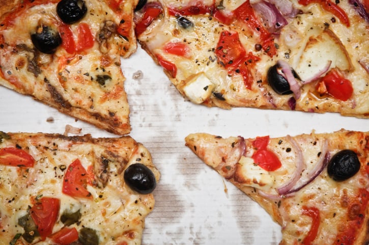 pizza with tomatoes, cheese, olives, and herbs