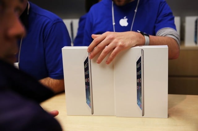 Apple employees sell the new iPad Air at the Apple Store on November 1, 2013