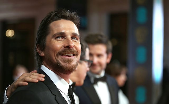 Actor Christian Bale smiles while walking the red carpet