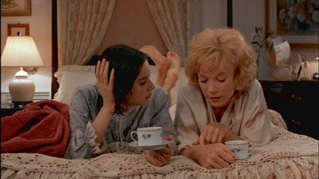 Debra Winger and Shirley MacLaine lay next to each other and drink tea in bed in Terms of Endearment