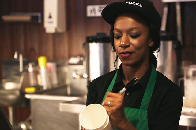 barista at Starbucks uses a market to label a drink