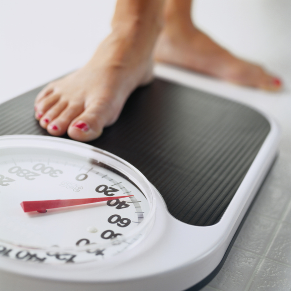 A woman steps on a scale