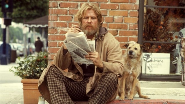 A man sits on a curb next to his dog in Down and Out in Beverly Hills