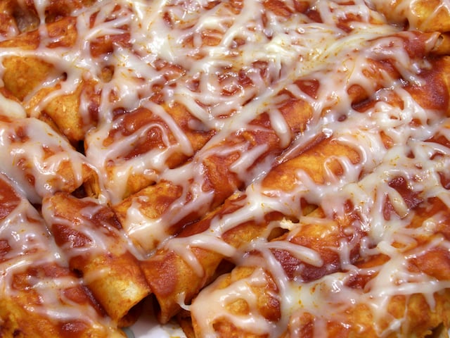 enchiladas covered with cheese and sauce