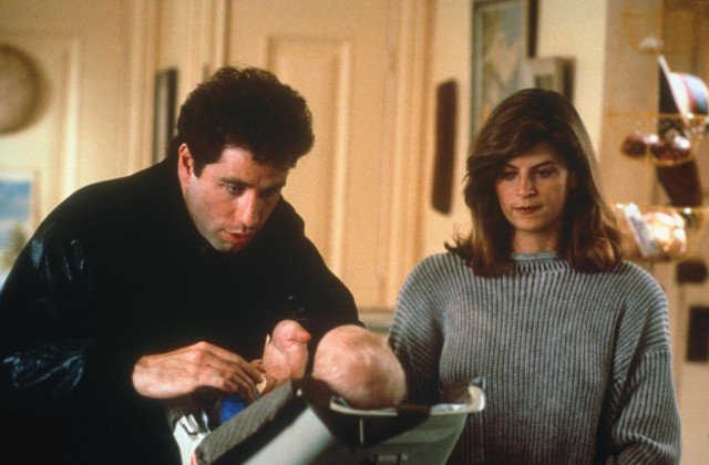John Travolta and Kirstie Alley lean over a baby in Look Who’s Talking