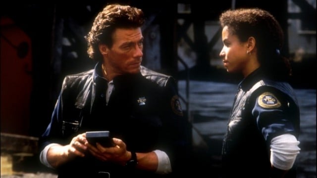 A female cop stands next to a man in Timecop