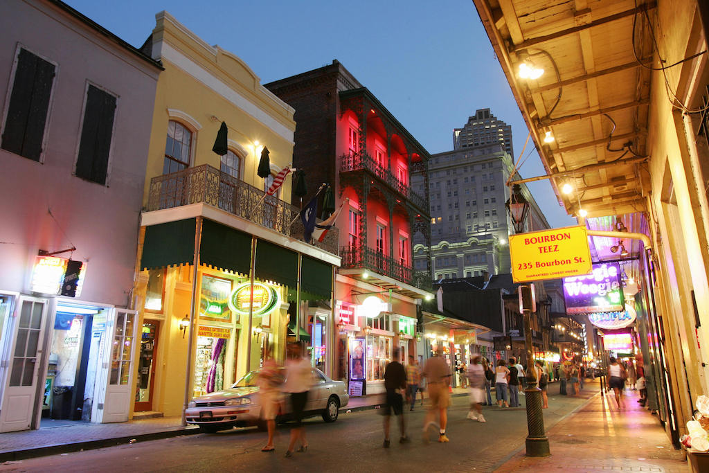 Dusk falls over Bourbon Street in the French Quarter of New Orleans, 11 July 2006, almost one year after Hurricane Katrina devastated the city. For tourists strolling through the French Quarter it's easy to forget that Hurricane Katrina ravaged New Orleans a year ago. The beignets are fresh, trinkets and designer clothes are artfully arranged in shop windows, and hurricanes are spinning in the bars on Bourbon Street. But while the music, food and good times have come back, the crowds have not and the city is struggling to make ends meet while its main industry remains crippled. With more than 10 million visitors a year, tourism was once a 5.5 billion dollar industry in New Orleans, accounting for 40 percent of the city's tax revenues and employing 85,000 people. (Photo by Robyn Beck/AFP/Getty Images)