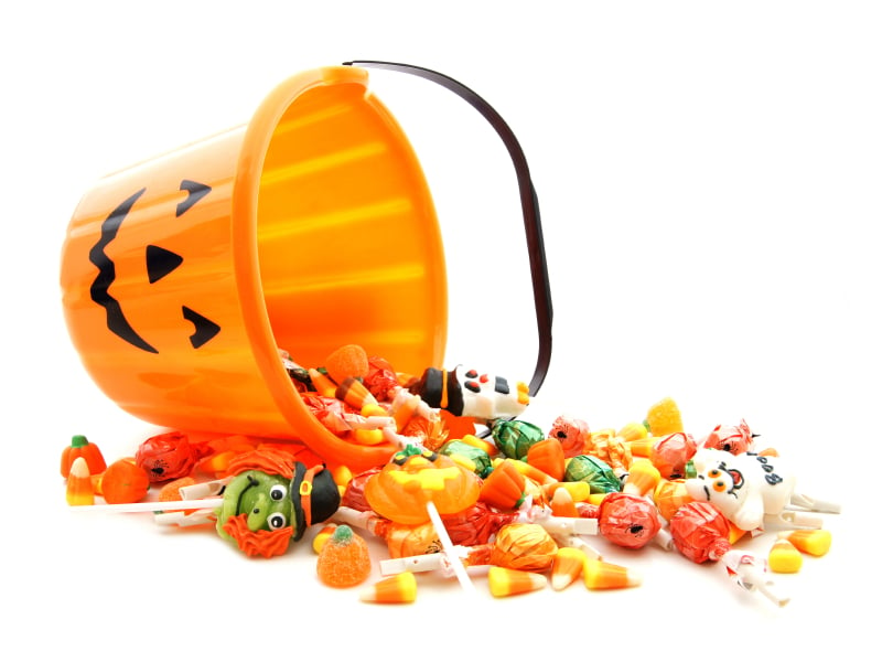 Halloween candy spilling from a pumpkin bucket