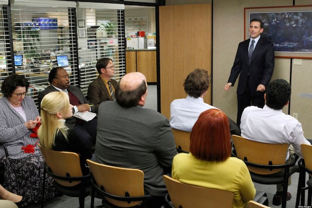 Steve Carell stands in front of a packed conference room in The Office