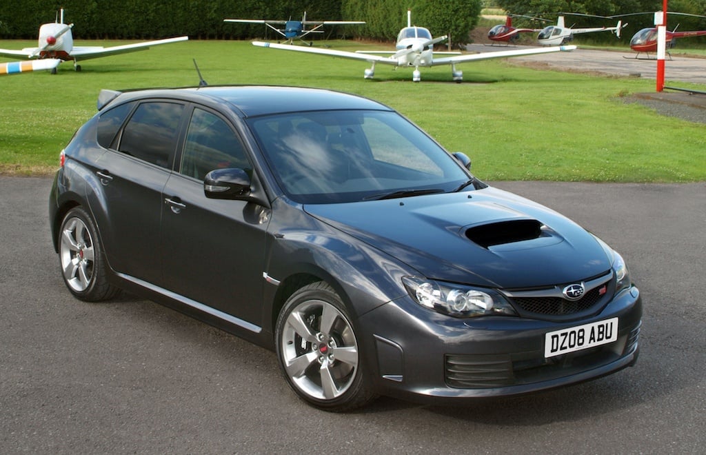 2009 Subaru Impreza 330S sits before some small aircraft