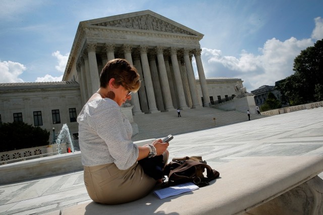 Kirsten Luna from Holland, Michigan, uses her smartphone outside the U.S. Supreme Court after a major ruling on cell phone privacy by the court June 25, 2014