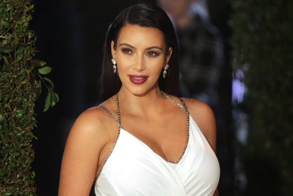 Kim Kardashian poses in a white dress.