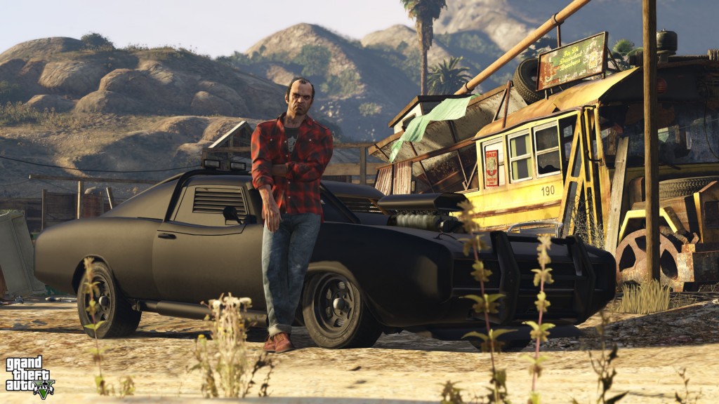 Trevor from GTA V leans against a car in the desert.
