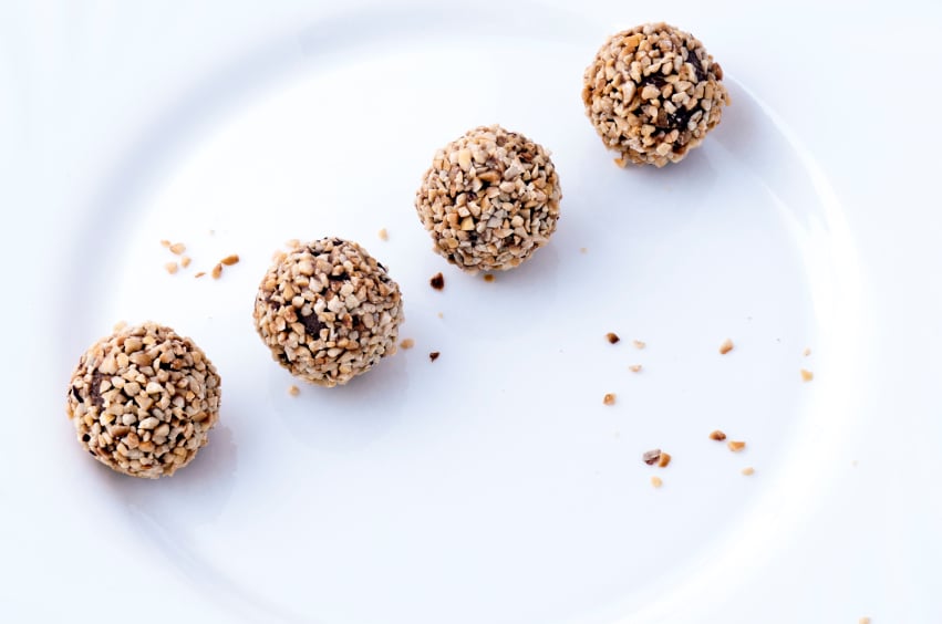 four truffles on a white plate